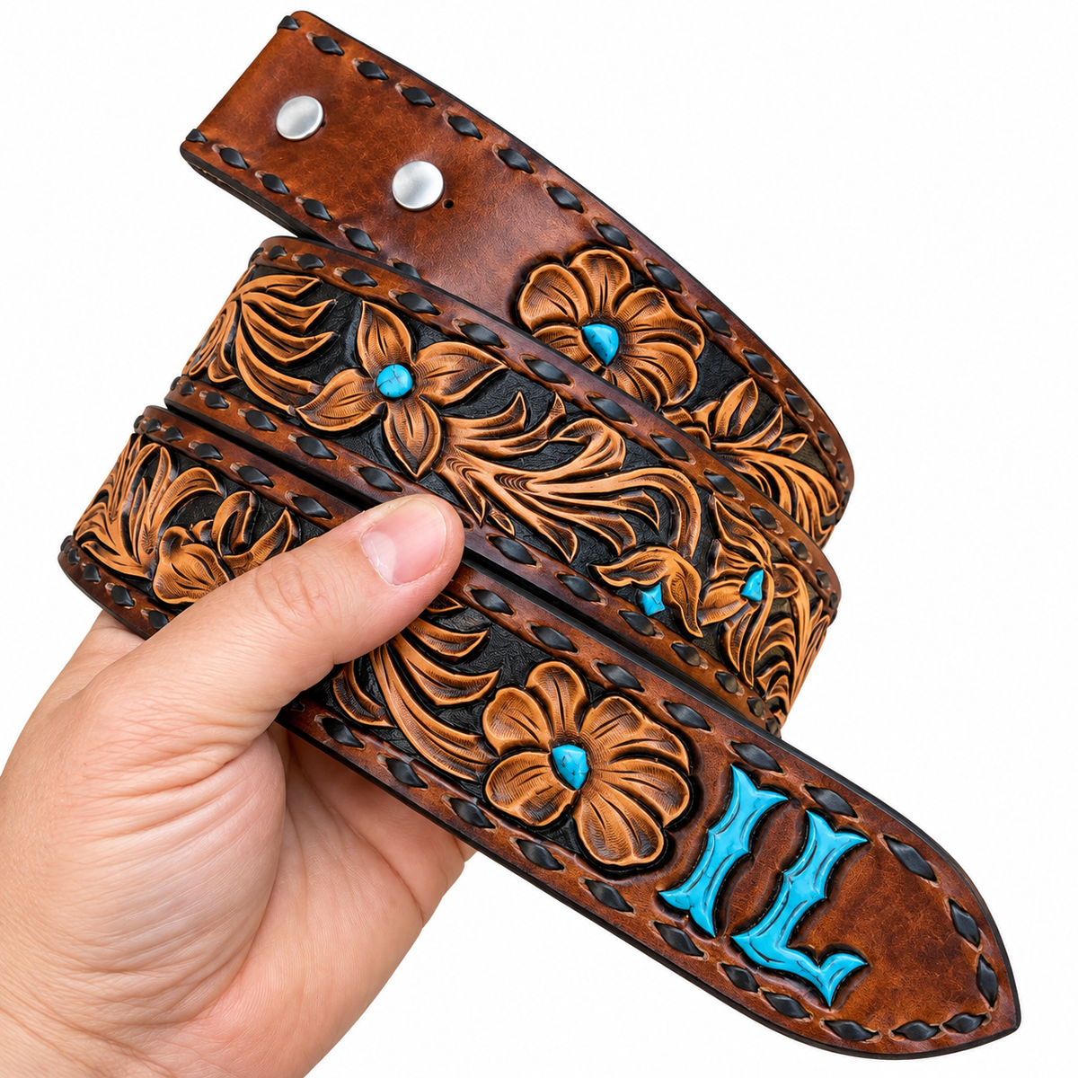 A hand holds a brown tooled leather belt with turquoise accents and silver-tone metal rivets against a plain white background.