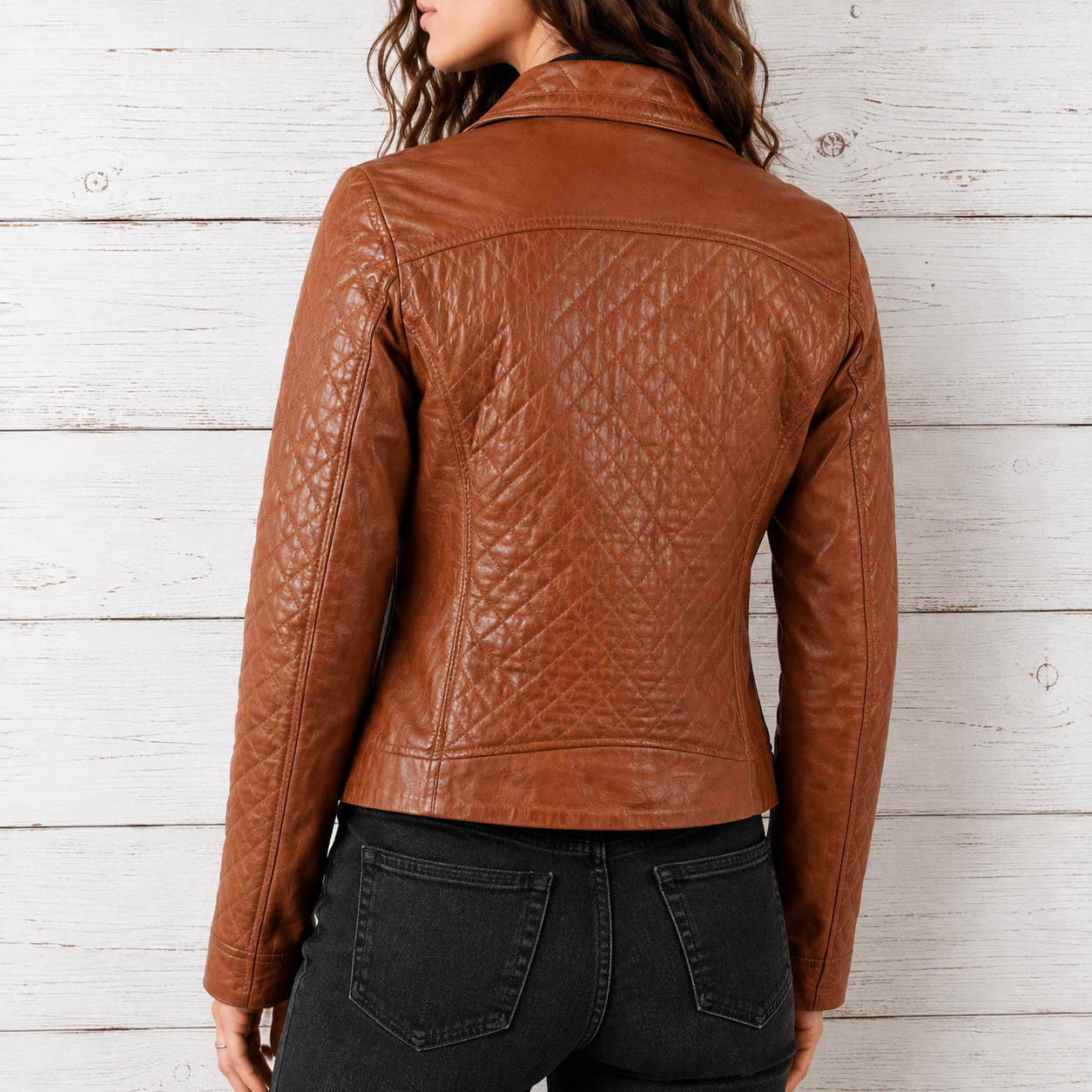 A woman wearing a brown quilted leather moto jacket, shown from the back 