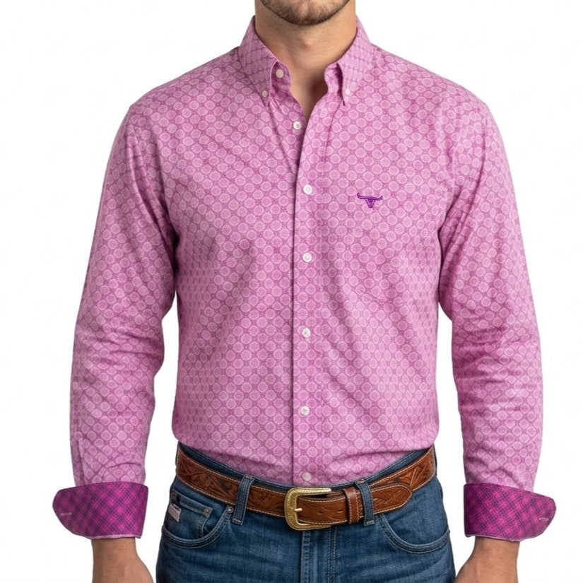 A man wearing a pink long-sleeve button-down shirt with a small geometric pattern, rolled-up sleeves showing a purple check lining, and blue jeans with a brown leather belt.