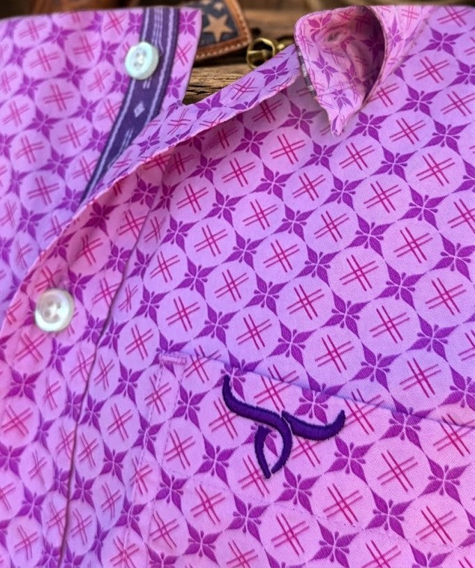Close-up of a purple and pink patterned shirt with a visible embroidered bull logo on the chest pocket, white buttons, and a patterned inner collar lining.