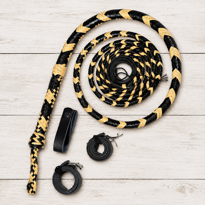 A coiled black and tan braided rope with three black accessories laid out on a light wood plank background.