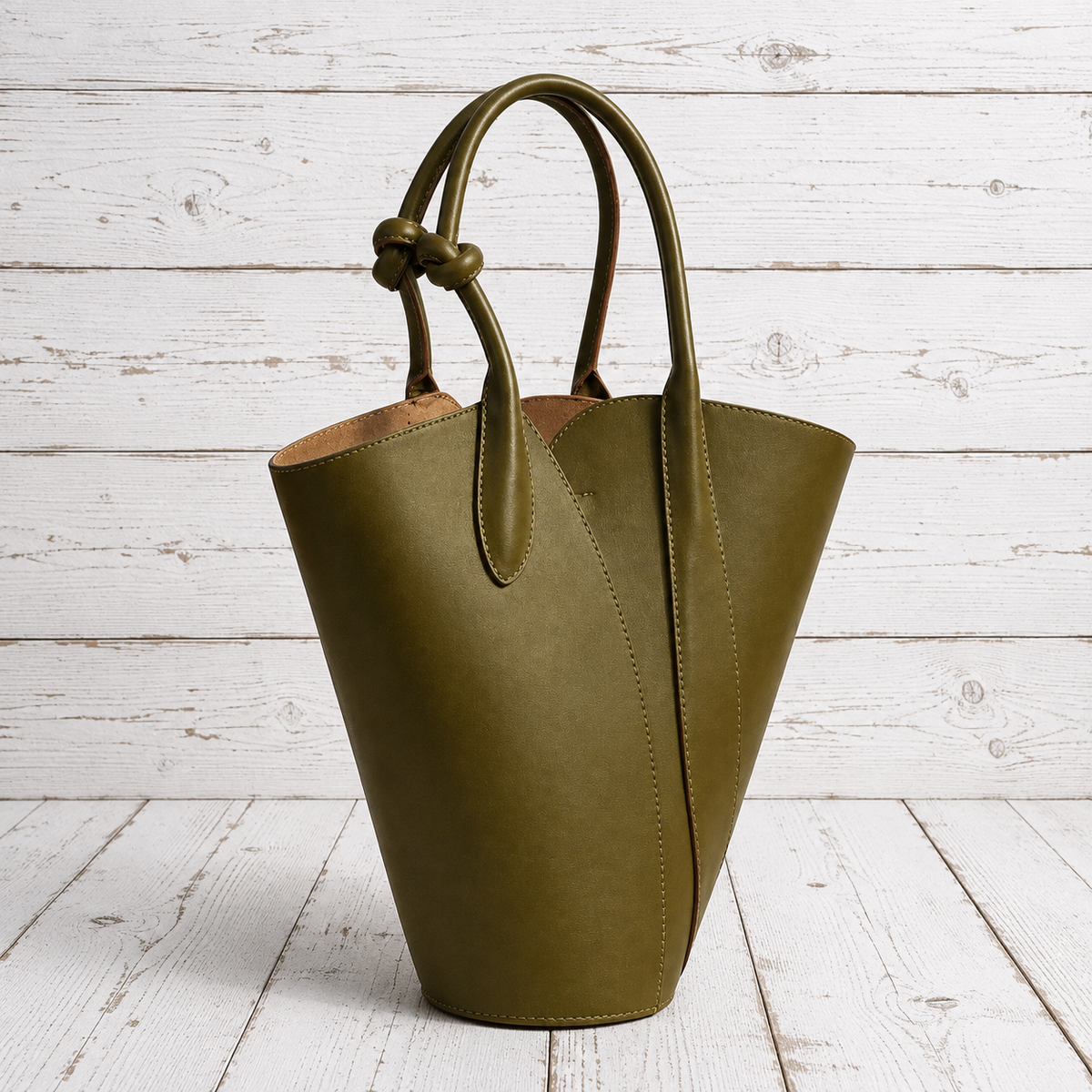 An olive green leather bucket bag with double top handles knotted at the top