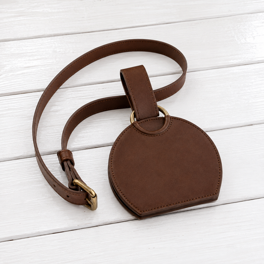 A brown leather shoulder bag with a semi-circular pouch body, adjustable strap, and gold-tone hardware